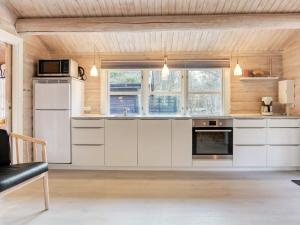 a kitchen with white cabinets and a stove top oven at Seaside Escape in Laeso - By Traum Ferienwohnungen in Læsø