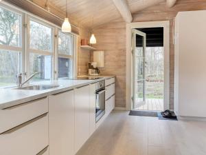 a kitchen with white cabinets and a large window at Seaside Escape in Laeso - By Traum Ferienwohnungen in Læsø