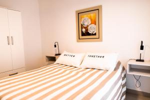 een slaapkamer met een bed met een gestreepte sprei bij COSTANERA APART in Villa María