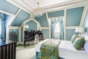 um quarto com uma cama, uma secretária e um lustre em Bentley London em Londres