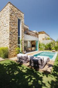 a villa with a swimming pool and a house at VILA PITHAYA - Casa Jambo Rosa in Japaratinga