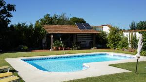 a swimming pool in a yard with a solar roof at Casa Rural Oliveira do Bairro in Oliveira do Bairro