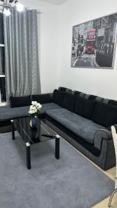a living room with a black couch and a coffee table at 2 bedrooms new brand with amazing view in Ajman 