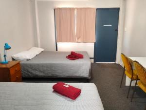 Habitación con 2 camas y puerta con ventana en Billabong Hotel Motel, en Cunnamulla