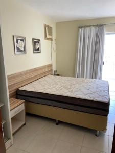 1 dormitorio con 1 cama en una habitación con ventana en Apartamento encantador de frente ao lago Corumbá, en Caldas Novas