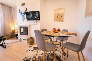 une salle à manger avec une table, des chaises et une cheminée dans l'établissement Studio 9, St John Park, à Bansko