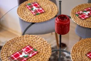 un tavolo di vetro sormontato da cestini di vimini con regali di Natale di Studio 9, St John Park a Bansko