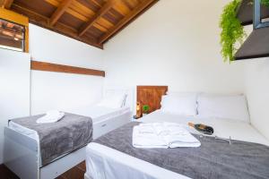 ein Schlafzimmer mit 2 Betten und Handtüchern darauf in der Unterkunft Casa Charmosa com Piscina em Barra do Una in Barra do Una