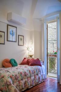 a bedroom with a bed with a flowered blanket and a window at B&B CORSO VITTORIO in Venosa
