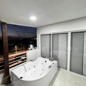 a large white bath tub in a room with windows at Hostal Taganga Plaza in Taganga