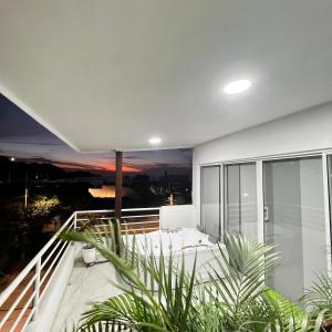 a white house with a balcony with plants at Hostal Taganga Plaza in Taganga