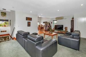 a living room with leather furniture and a christmas tree at Mi Castillo on Hatea Drive in Whangarei