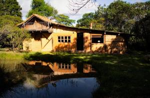 a house with a reflection in a body of water at Hotel Ráquira Silvestre Lodge in Tinjacá