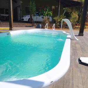 a large swimming pool with a white bath tub at Casa em Caldas - PISCINA SOLAR E ELETRICA in Caldas Novas