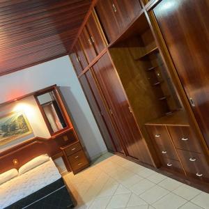 a room with wooden cabinets and a bed in it at Casa em Caldas - PISCINA SOLAR E ELETRICA in Caldas Novas
