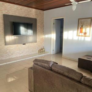 a living room with a couch and a flat screen tv at Casa em Caldas - PISCINA SOLAR E ELETRICA in Caldas Novas