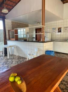 een keuken met een houten tafel met fruit erop bij Casa em Caldas - PISCINA SOLAR E ELETRICA in Caldas Novas