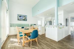 a kitchen and dining room with a wooden table and chairs at Casa Del Alba in Galveston