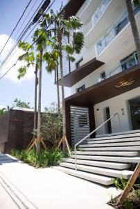 a building with stairs and palm trees in front of it at Soha Panorama B13 King Bed High Floor Balcony View in Santiago de los Caballeros