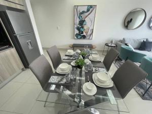 a dining table and chairs in a living room at Soha Panorama B13 King Bed High Floor Balcony View in Santiago de los Caballeros