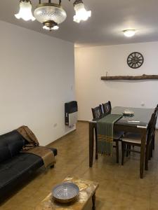 a living room with a black couch and a table at hermoso departamento en pleno centro de córdoba, zonas segur y tranquila in Cordoba