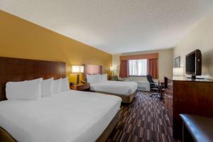 um quarto de hotel com duas camas e uma televisão em Best Western Falcon Plaza em Bowling Green
