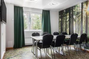 - une salle de conférence avec des rideaux verts, une table et des chaises dans l'établissement Best Western Gustaf Froding Hotel & Konferens, à Karlstad