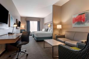 Best Western Dartmouth Hotel & Suites في هاليفاكس: غرفة في الفندق بها سرير وأريكة ومكتب