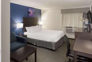 um quarto de hotel com uma cama e uma cadeira em SureStay Hotel by Best Western Presque Isle em Presque Isle