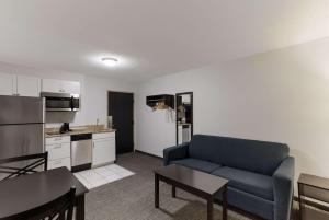 a living room with a couch and a kitchen at SureStay Hotel by Best Western Presque Isle in Presque Isle