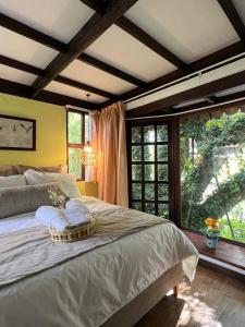 um quarto com uma cama e uma grande janela em Chalet Andino Sesquile em Suesca
