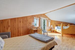 sypialnia z łóżkiem w pokoju z drewnianymi ścianami w obiekcie MontFJORD - Chalets, vue spectaculaire et SPA. ChantaFJORD #4 w mieście Sacré-Coeur-Saguenay