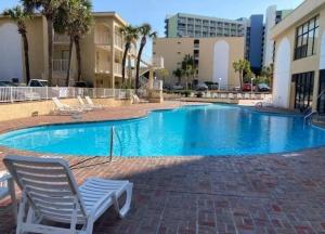 een blauw zwembad met een stoel voor een gebouw bij Ocean front comfy condo w/kitchen, sleeps 4, Snowbird Paradise in Myrtle Beach