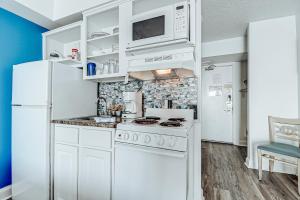 cocina con electrodomésticos blancos y nevera blanca en Ocean front comfy condo w/kitchen, sleeps 4, Snowbird Paradise en Myrtle Beach