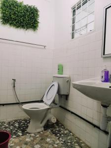 a bathroom with a toilet and a sink at VIRTA Guesthouse in Sandakan