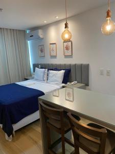 Schlafzimmer mit einem Bett und einem Tisch mit Stühlen in der Unterkunft Flat no Transamerica Hotel in Campos dos Goytacazes