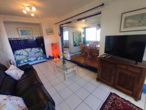 a living room with a couch and a flat screen tv at TAHITI - Iaorana Maeva Apartment in Punaauia