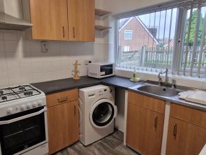 a kitchen with a washing machine and a sink at The Pride of Manchester, Trafford in Manchester