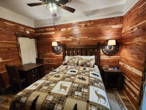 1 dormitorio con 1 cama y paredes de madera en Log Cabin Inn en Eureka Springs