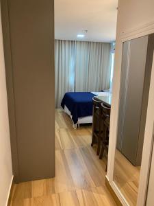 een slaapkamer met een bed en een tafel in een kamer bij Flat no Transamerica Hotel in Campos dos Goytacazes