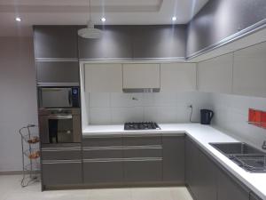 a kitchen with gray cabinets and white counter tops at 1670 House in Mendoza
