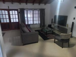 sala de estar con sofá y TV en 1670 House en Mendoza