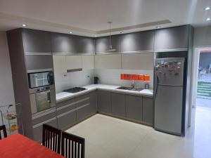 a kitchen with gray cabinets and a stainless steel refrigerator at 1670 House in Mendoza