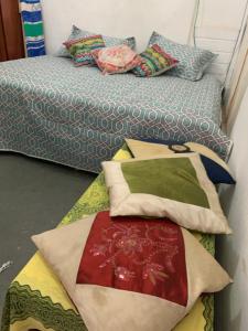 Duas camas com almofadas num quarto em Kitnet Centro RJ no Rio de Janeiro