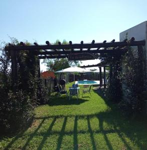 eine Pergola mit einem Tisch und Stühlen im Hof in der Unterkunft La Bendición in Campo Quijano