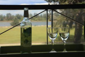 a bottle of wine and two glasses on a table at Sea Breeze on the Esplanade in Lakes Entrance