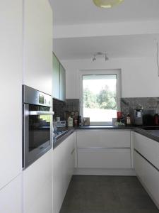 ゼーボーデンにあるHaus Lichtblickの白いキャビネットと窓付きのキッチン
