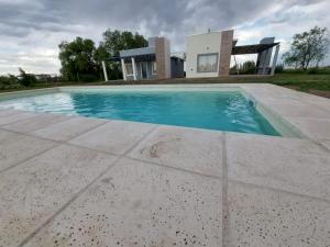 a swimming pool in front of a house at Complejo Blend in San Rafael