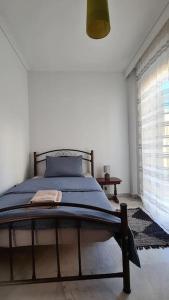 a bedroom with a bed with a blue blanket on it at Fori's Nest / SKG in Thessaloniki