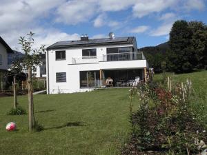 una casa blanca en una colina con un patio en Haus Lichtblick, en Seeboden